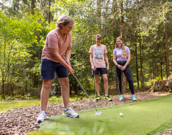 Drei Jugendliche spielen Adventure Golf