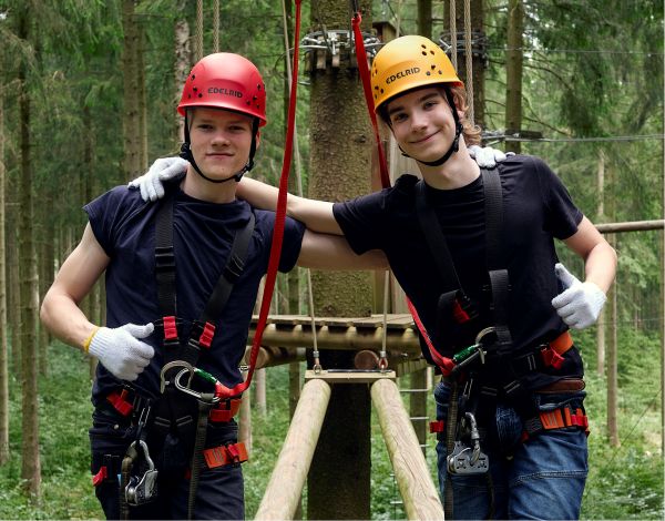 Zwei Jugendliche stehen gemeinsam in der Kletteranlage