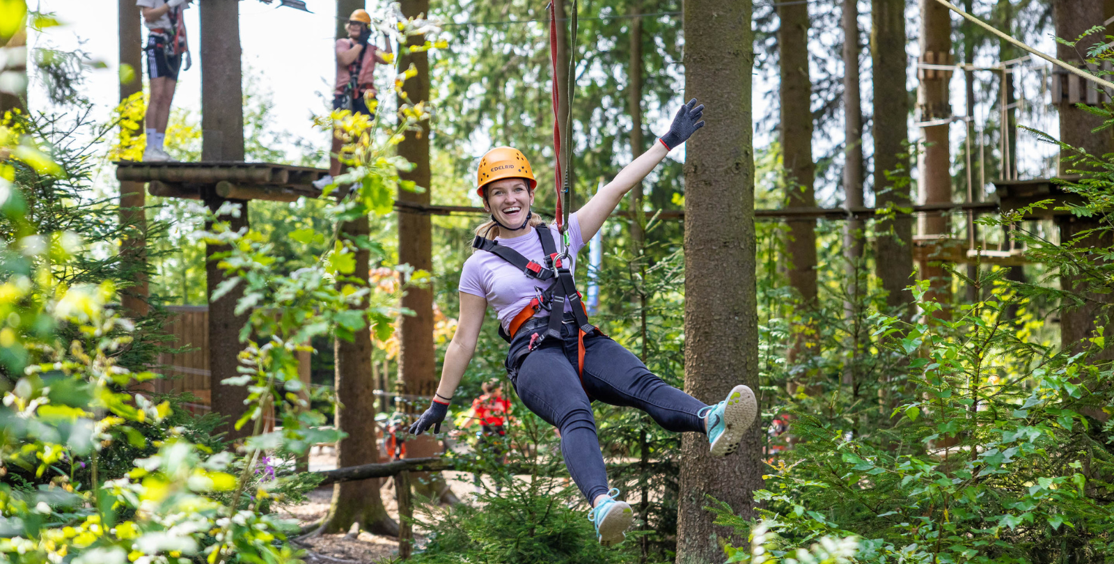 Eine Frau schwebt an einem Seil durch den Kletterpark