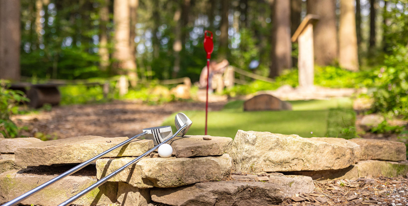 Stillleben - Zwei Golfschlger mit Golfball auf einer Natursandsteinmauer