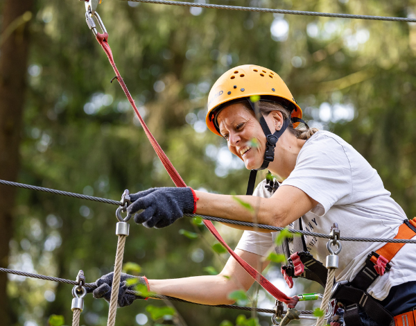 lachende Frau klettert an einem Element