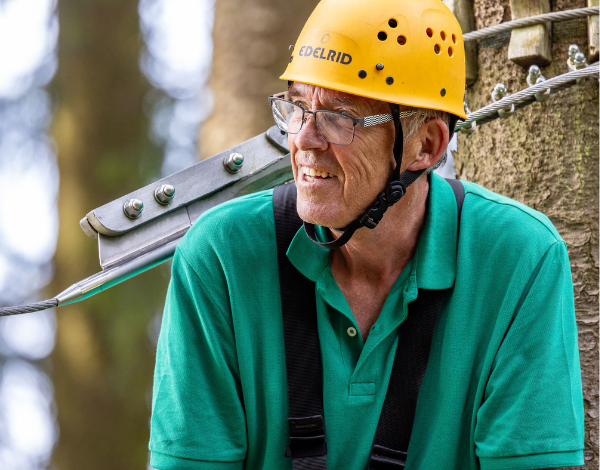 lterer Mann wartet auf einer Kletterplattform