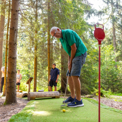 Ein Mann und einen Jugendlicher beim Golf spielen